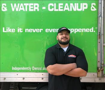 Male crew member in front of SERVPRO truck in SERVPRO shirt