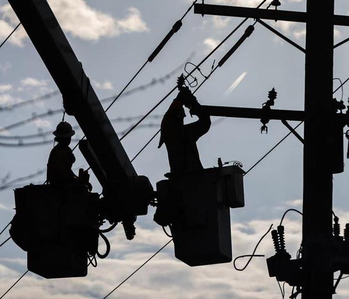Silhouette of crew working on power lines